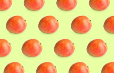 Açık yeşil arka planda lezzetli olgun mangolar.