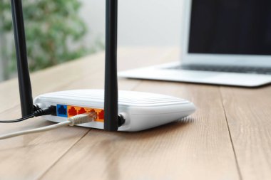 Modern Wi-Fi yönlendirici ve laptop ahşap masa içinde, yakın plan