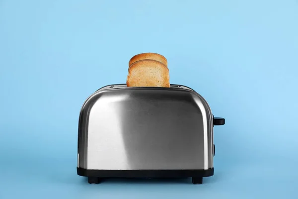 Elektrische Broodrooster Met Brood Plakjes Lichtblauwe Achtergrond — Stockfoto