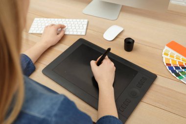 Profesyonel tasarımcı masadaki grafik tablet üzerinde çalışıyor, yakın plan