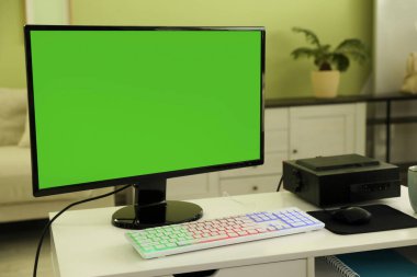 Modern bilgisayar ve RGB klavyesi beyaz masa içinde. Mokup yeşil ekran
