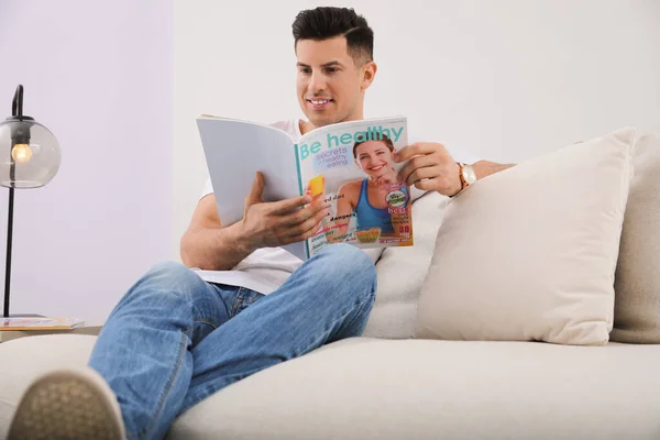 Mann Liest Magazin Auf Sofa Wohnzimmer — Stockfoto