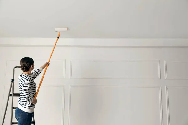 Junge Frau Bemalt Decke Innen Mit Weißem Farbstoff Rückansicht Raum — Stockfoto