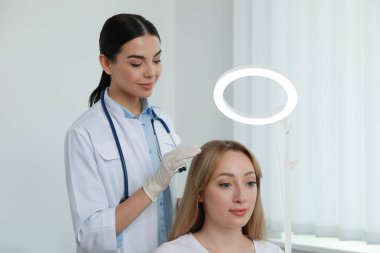 Hafif klinikte trikoloğu ziyaret eden genç bir kadın.