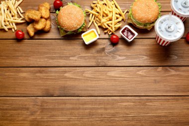 Düz kompozisyon ve ahşap masada lezzetli fast food menüsü. Metin için boşluk