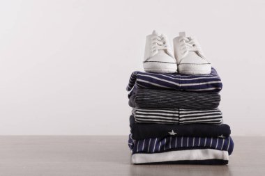 Erkek çocuğun kıyafetleri ve ayakkabıları beyaz arka plana karşı ahşap masada, mesaj için yer