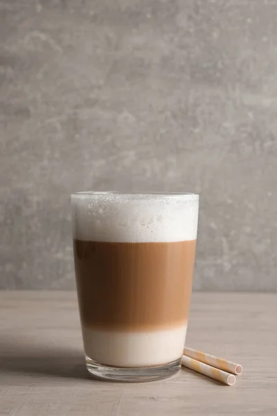 Glas Köstlichen Geschichteten Kaffees Und Strohhalme Auf Holztisch Vor Hellgrauem — Stockfoto