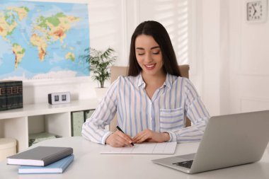 Seyahat acentesinde masa başında çalışan mutlu yönetici.