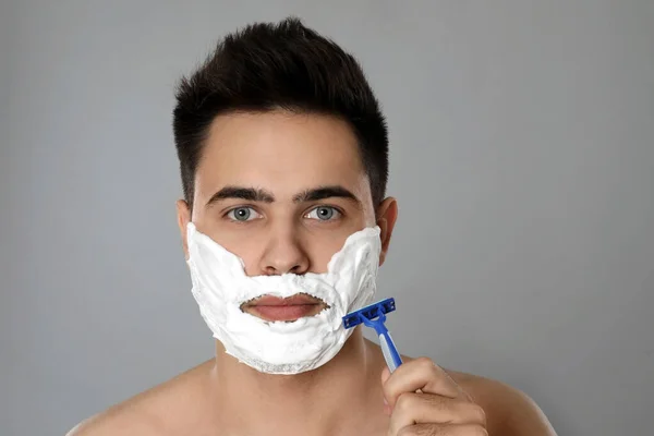 Handsome Young Man Shaving Razor Grey Background — Stock Photo, Image
