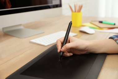 Profesyonel tasarımcı masadaki grafik tablet üzerinde çalışıyor, yakın plan