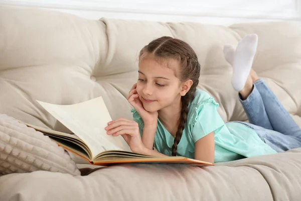 Милая Маленькая Девочка Читает Книгу Диване Дома — стоковое фото
