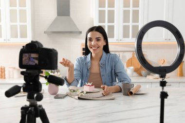 Lezzetli kek videosu olan blogcu evde mutfakta. Yüzük lambası ve kamera kullanarak.