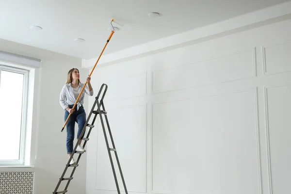 Giovane Donna Pittura Soffitto Con Tintura Bianca All Interno Spazio — Foto Stock