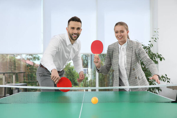 Business people playing ping pong in office