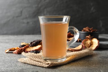 Cam bardakta lezzetli gübre ve gri masada kurutulmuş meyve.