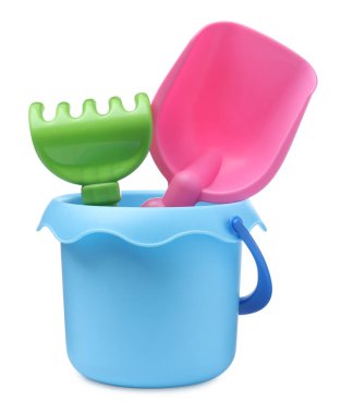 Beyaz arka planda kürek ve tırmıkla plastik oyuncak kovası