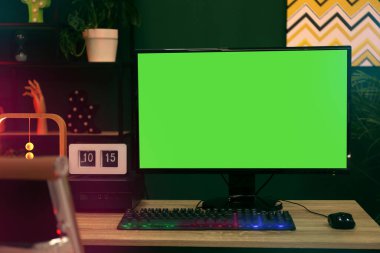 Modern bilgisayar ve RGB klavyesi ahşap masa içinde. Mokup yeşil ekran