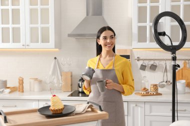 Evdeki mutfakta kahve videosu kaydeden blogcu. Halka lamba ve akıllı telefon kullanarak.