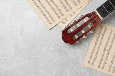 Composition with guitar and music notations on light table, flat lay. Space for text clipart