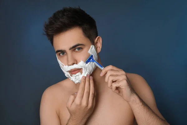 Guapo Joven Afeitándose Con Afeitadora Sobre Fondo Azul — Foto de Stock