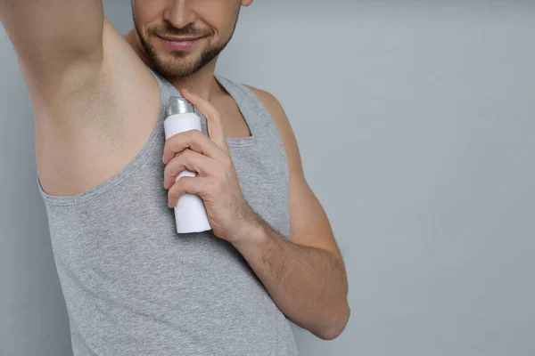 Hombre Aplicando Desodorante Sobre Fondo Gris Primer Plano Espacio Para — Foto de Stock
