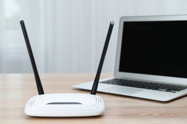 Modern Wi-Fi yönlendirici ve laptop ahşap masa içinde.