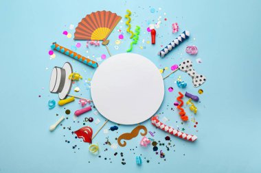 Karnaval eşyalarıyla düz kompozisyon ve açık mavi arka planda boş kart. Metin için boşluk