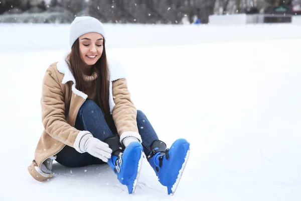 Mujer Feliz Usando Patines Figura Mientras Está Sentado Pista Hielo — Foto de Stock