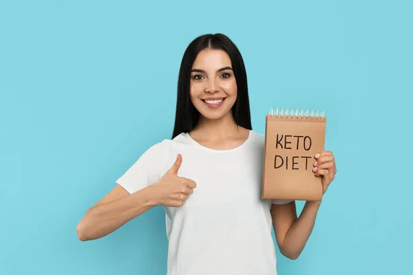 Mujer Feliz Sosteniendo Cuaderno Con Palabras Keto Dieta Sobre Fondo — Foto de Stock
