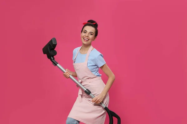 ピンクの背景に掃除機付き主婦 — ストック写真
