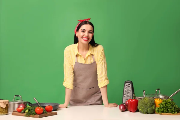 Молодая Домохозяйка Белым Столом Овощами Различной Посудой Зеленом Фоне — стоковое фото