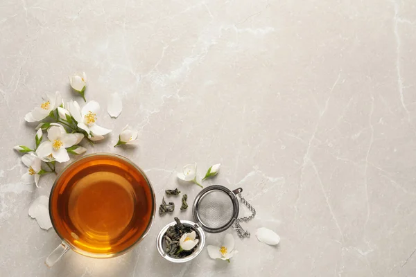 Glas Kopp Aromatisk Jasmin Och Färska Blommor Grått Bord Platt — Stockfoto