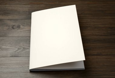 Tahta masadaki boş kağıt broşürü. Tasarım için model