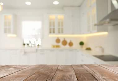 Boş ahşap masa ve şık mutfak manzarası bulanık. Tasarım için model