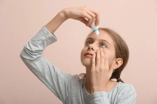 Roztomilé Dívka Pomocí Oční Kapky Béžové Pozadí — Stock fotografie