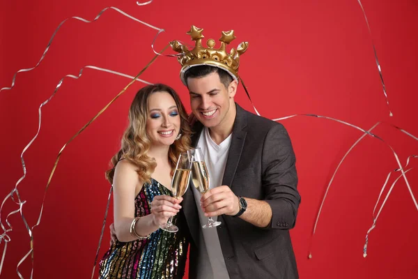 Gelukkig Paar Met Champagne Vallen Naar Beneden Serpentines Rode Achtergrond — Stockfoto