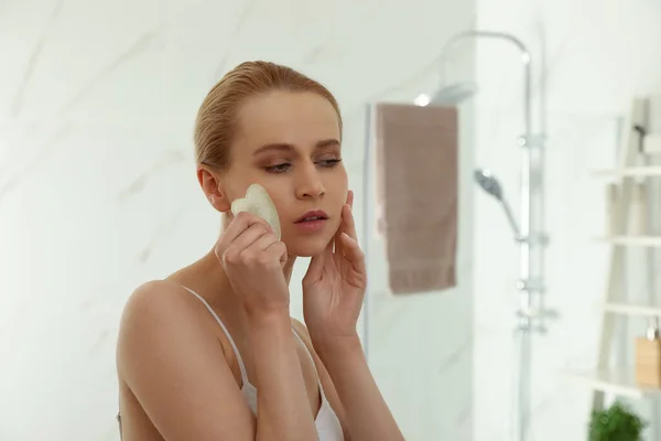 Mulher Bonita Fazendo Massagem Facial Com Ferramenta Gua Sha Banheiro — Fotografia de Stock