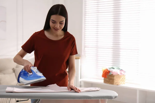 Young Woman Ironing Clean Sweatshirt Home Space Text — Stock Photo, Image