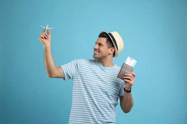 Mężczyzna Turysta Posiadający Paszport Biletem Zabawkowym Samolotem Turkusowym Tle — Zdjęcie stockowe