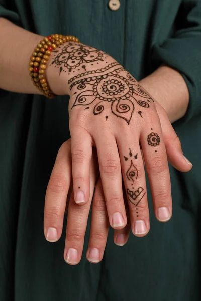 Woman with beautiful henna tattoo on hand, closeup. Traditional mehndi