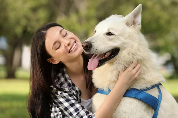 ティーン女の子抱擁彼女の白いですスイスシェパード犬で公園 — ストック写真