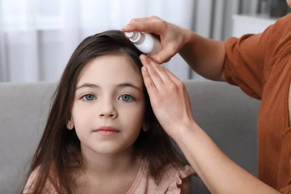 Mother Using Lice Treatment Spray Her Daughter Hair Indoors — Stock Photo, Image