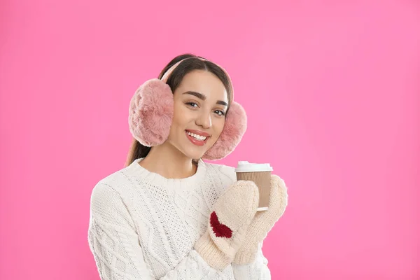 Hermosa Mujer Joven Orejeras Con Taza Bebida Sobre Fondo Rosa —  Fotos de Stock