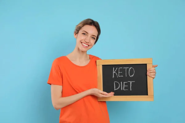 Frau Hält Tafel Mit Satz Keto Diet Auf Hellblauem Hintergrund — Stockfoto