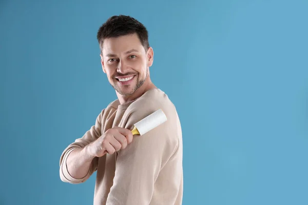 Homem Limpeza Roupas Com Rolo Fiapos Fundo Azul Claro Espaço — Fotografia de Stock