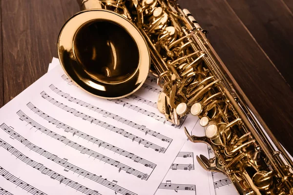 Piękny Saksofon Nuty Drewnianym Tle Zbliżenie — Zdjęcie stockowe