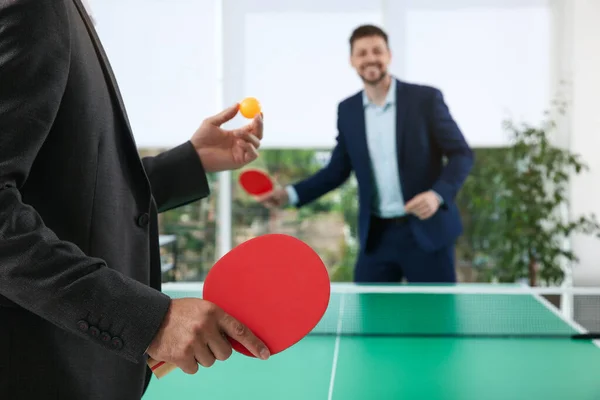 オフィスで卓球をしているビジネスマンは テニスラケットに焦点を当て — ストック写真
