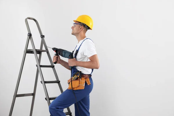 Arbeiter Mit Elektrobohrmaschine Auf Leiter Drinnen Platz Für Text — Stockfoto