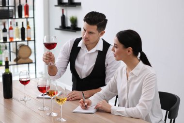 Sommelier 'ler kapalı bir masada farklı türde şarap tadıyorlar.