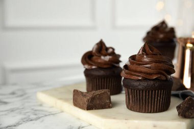 Beyaz mermer masada kremalı lezzetli çikolatalı kekler. Metin için boşluk